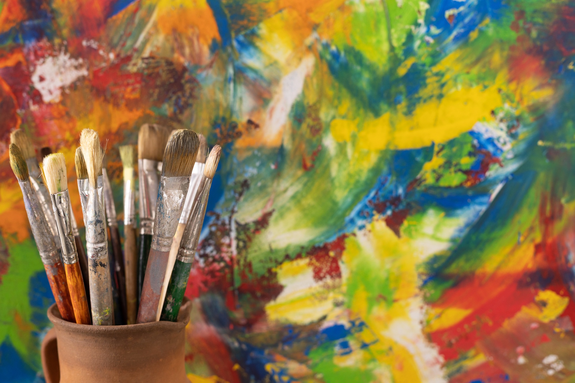 Paint brush in clay jug and oil painting background texture. Paintbrush painting and art still life